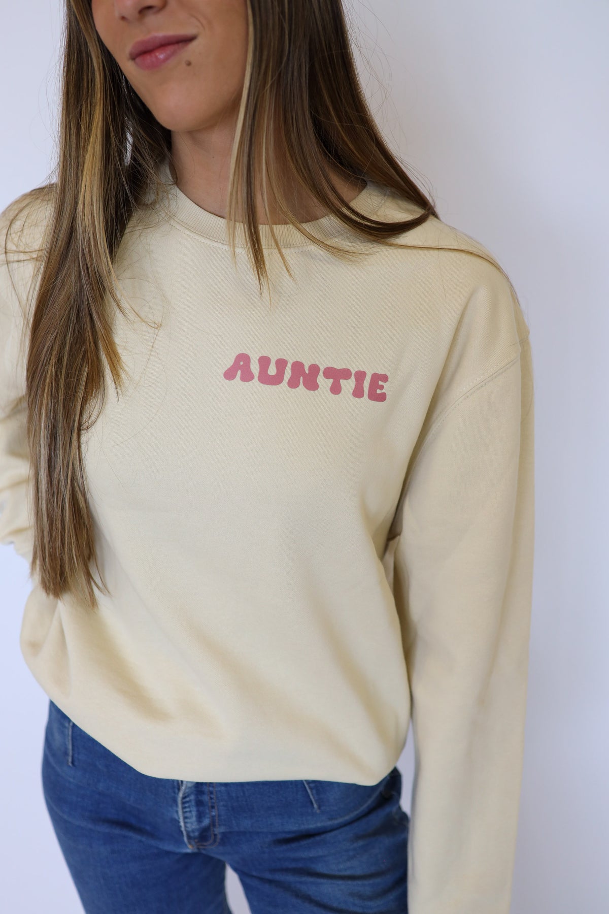 Detalle del texto rosa en el pecho de la sudadera Surfer beige