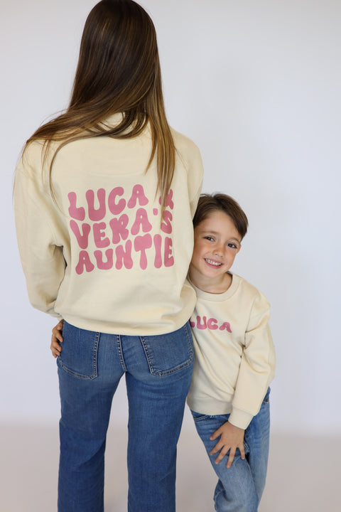 Sudadera Surfer beige con texto rosa en la espalda y prenda infantil a juego
