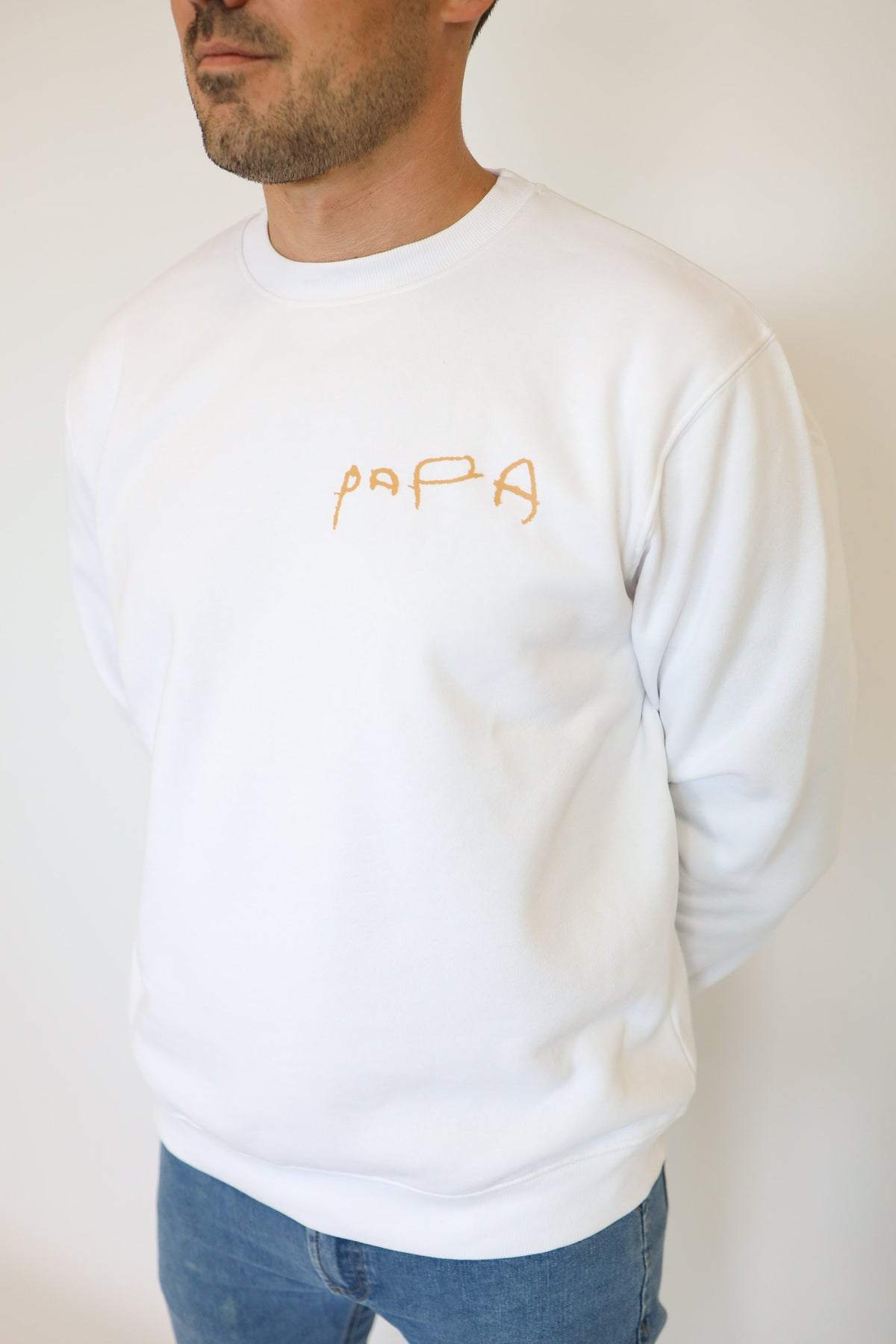 Detalle de una palabra escrita a mano en sudadera blanca