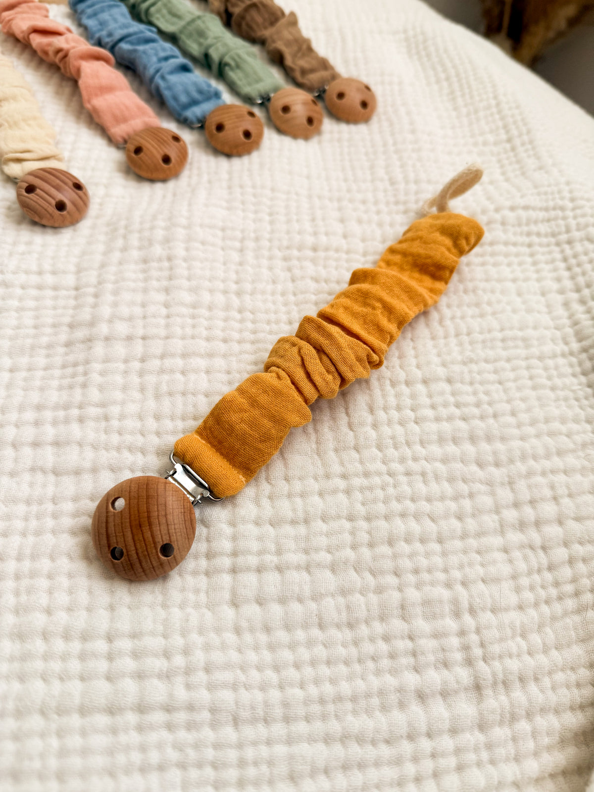 Chupetero de tela mostaza con pinza de madera