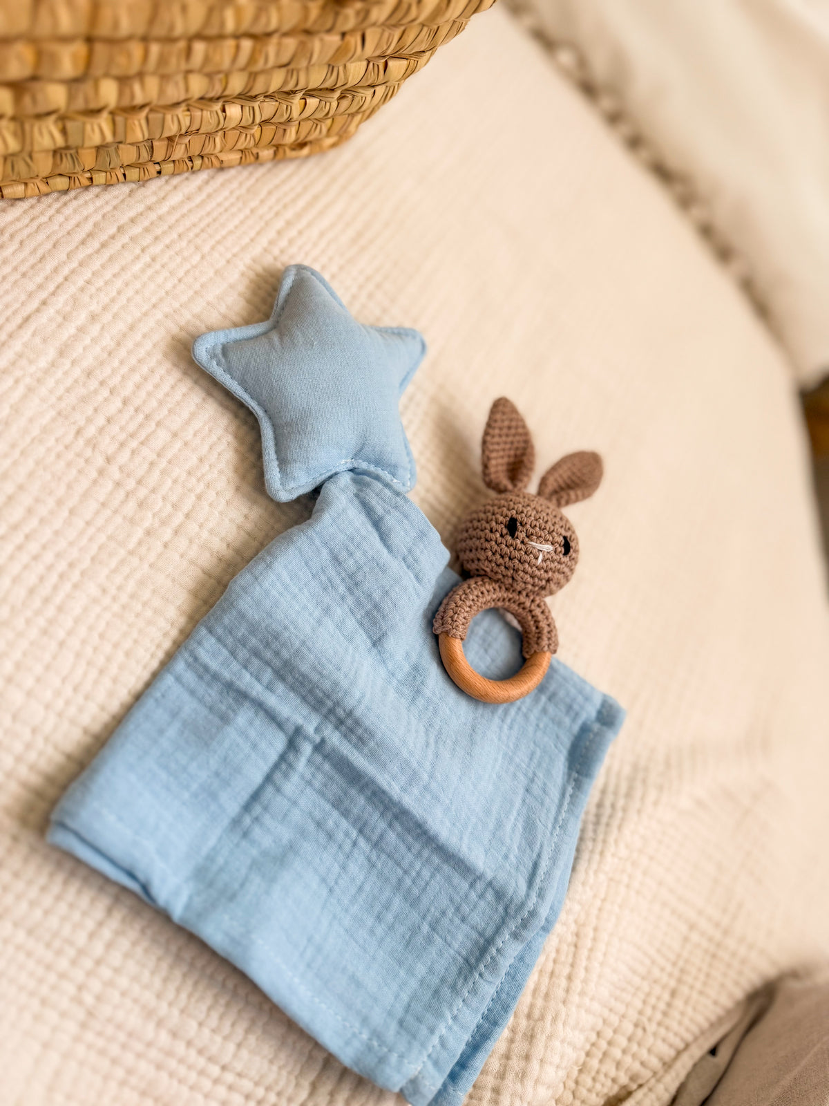 Doudou con estrella azul junto a sonajero de conejo